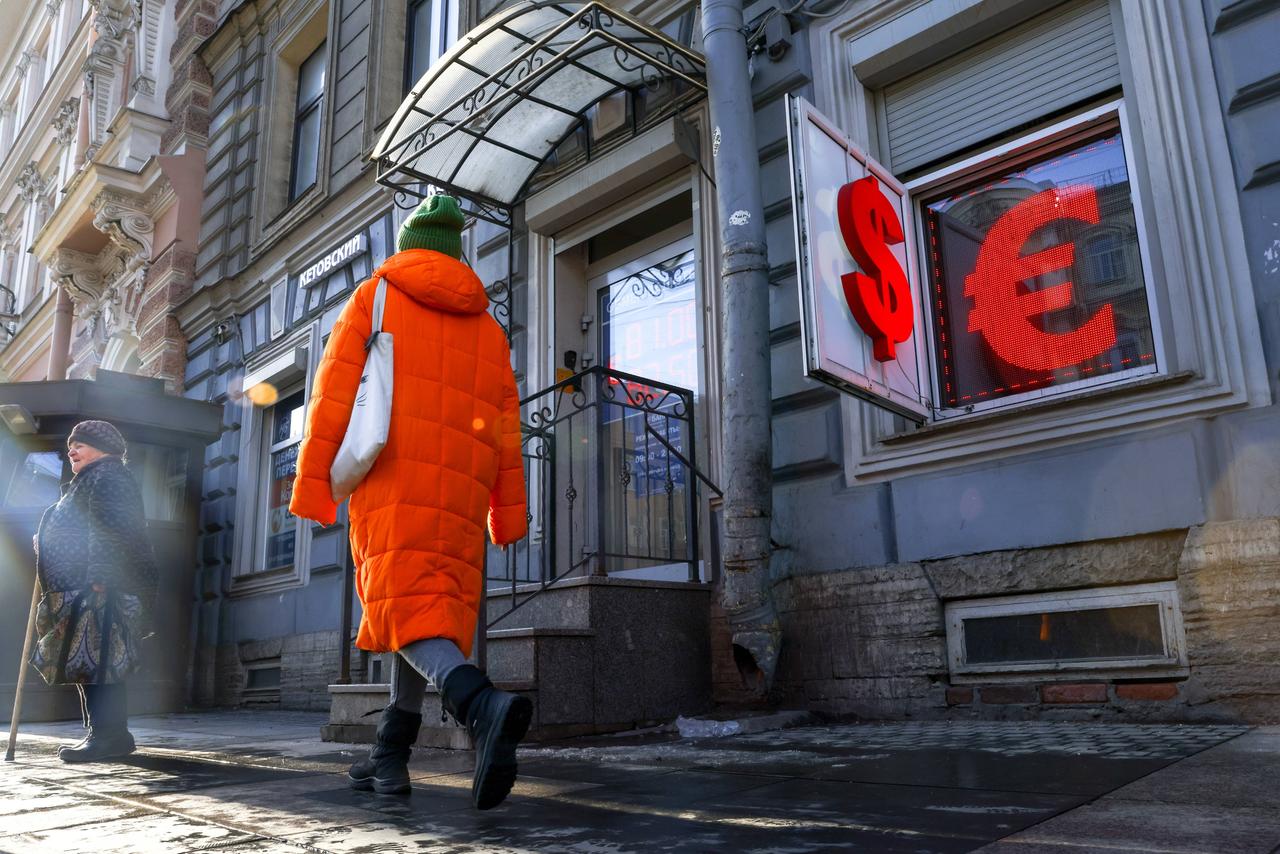 Eine Frau in St. Petersburg geht an einer Wechselstube vorbei