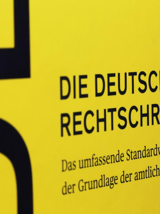 Nahaufnahme des Covers der 28. Auflage des Dudens. Schwarze Schrift auf gelben Grund.