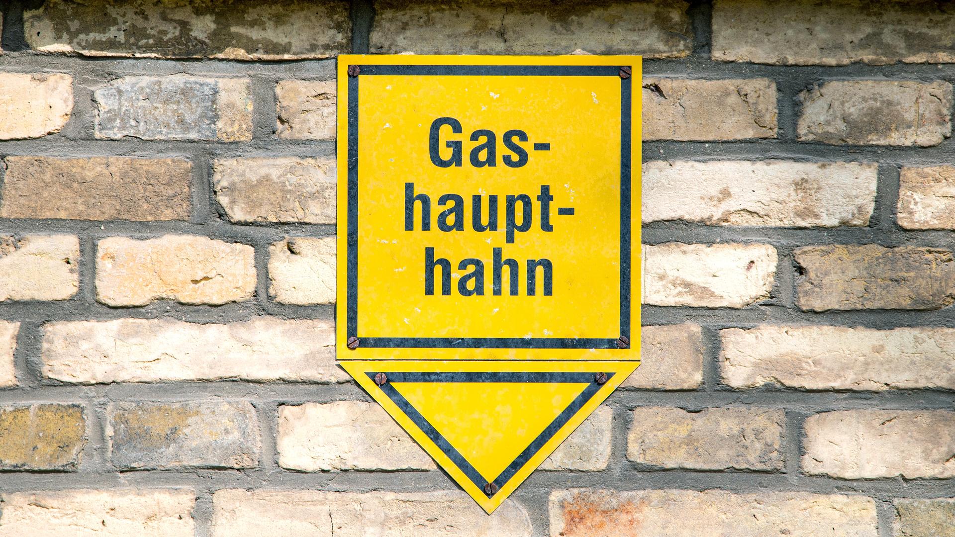 Ein gelbes Hinweisschild mit der Aufschrift "Gashaupthahn" ist an einer Hauswand befestigt. Ein gelbes Hinweisschild mit der Aufschrift "Gashaupthahn" ist an einer Hauswand befestigt.