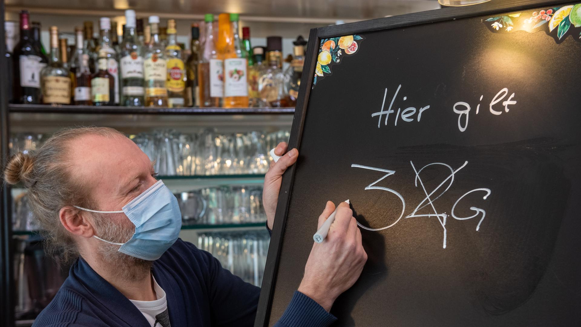 Gastronom Jörg Hicker passt eine Informationstafel an. Ab dem 04.03.2022 gilt in der bayerischen Gastronomie die 3G-Regel.
Gastronom Jörg Hicker passt eine Informationstafel an. Ab dem 04.03.2022 gilt in der bayerischen Gastronomie die 3G-Regel.