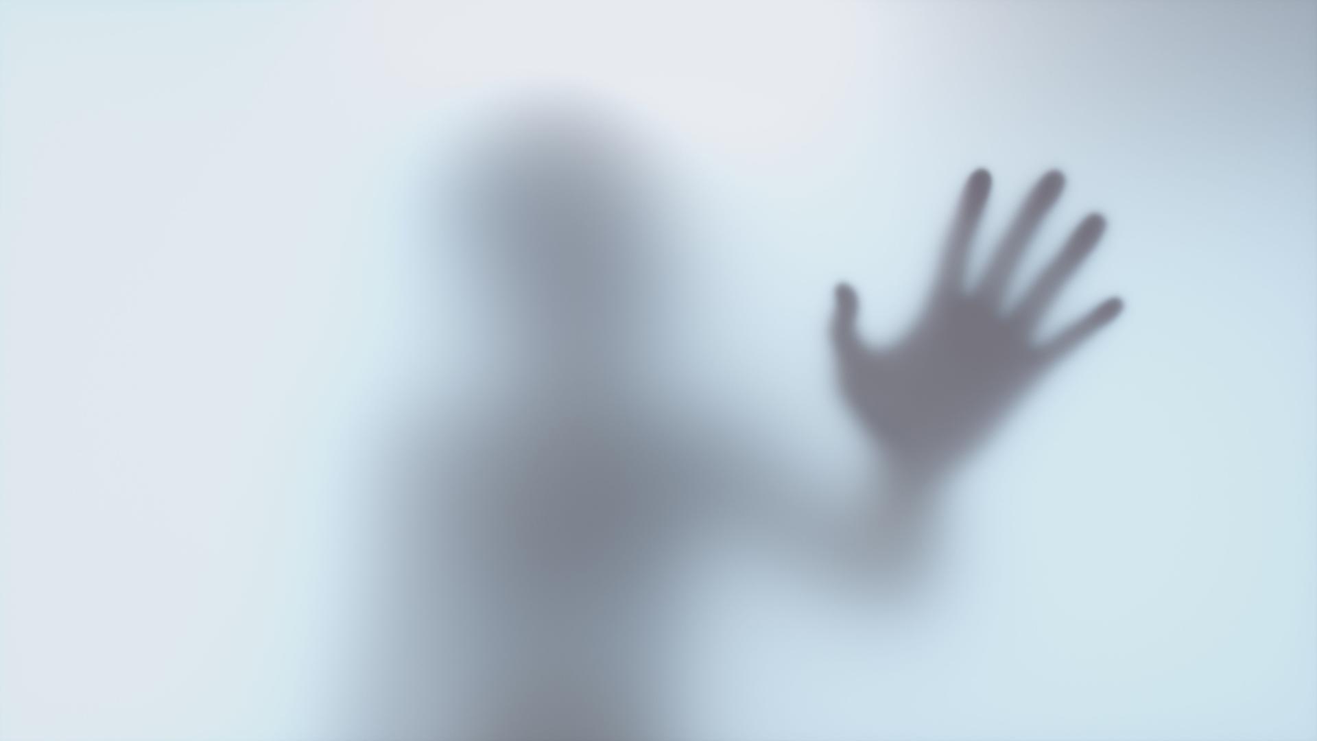 Der Schatten einer Hand hinter einer Milchglasscheibe Der Schatten einer Hand hinter einer Milchglasscheibe