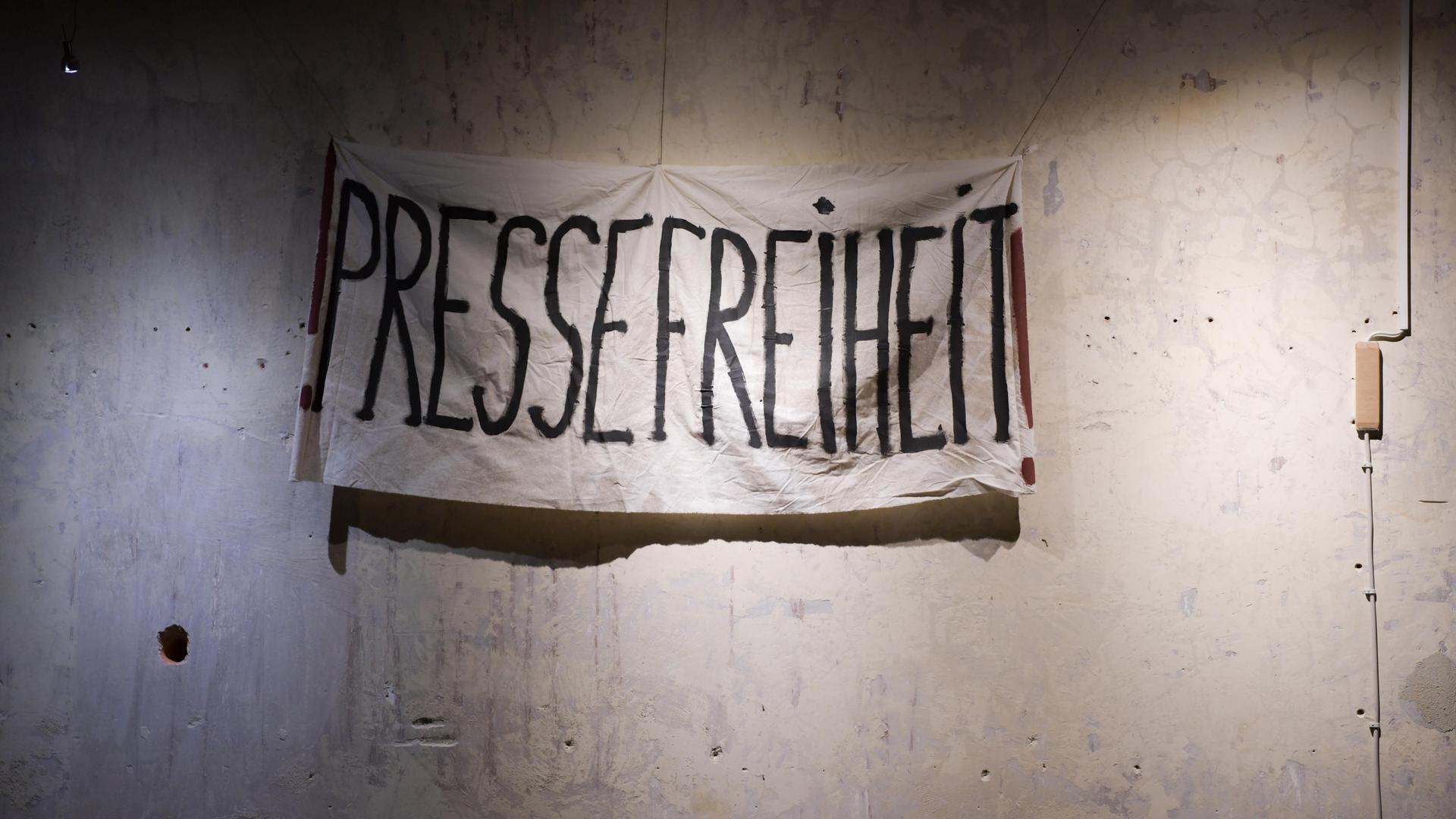 Ein Transparent mit der Aufschrift "Pressefreiheit" hängt vor einer unverputzten Wand. Es stammt aus den Dreharbeiten zum historischen ZDF-Dreiteiler "The Wall". Ein Transparent mit der Aufschrift "Pressefreiheit" hängt vor einer unverputzten Wand. Es stammt aus den Dreharbeiten zum historischen ZDF-Dreiteiler "The Wall".
