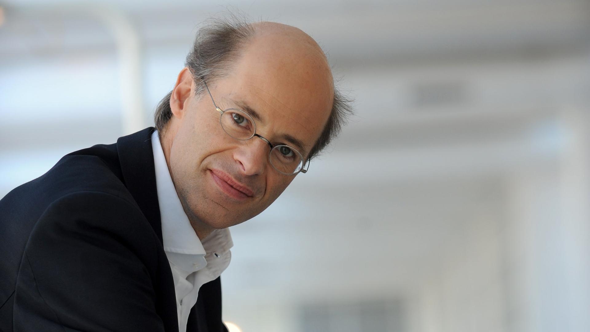 Der Journalist Michael Thumann steht mit aufgelehnten Ellenbogen an einer Balustrade. Der Journalist Michael Thumann steht mit aufgelehnten Ellenbogen an einer Balustrade.