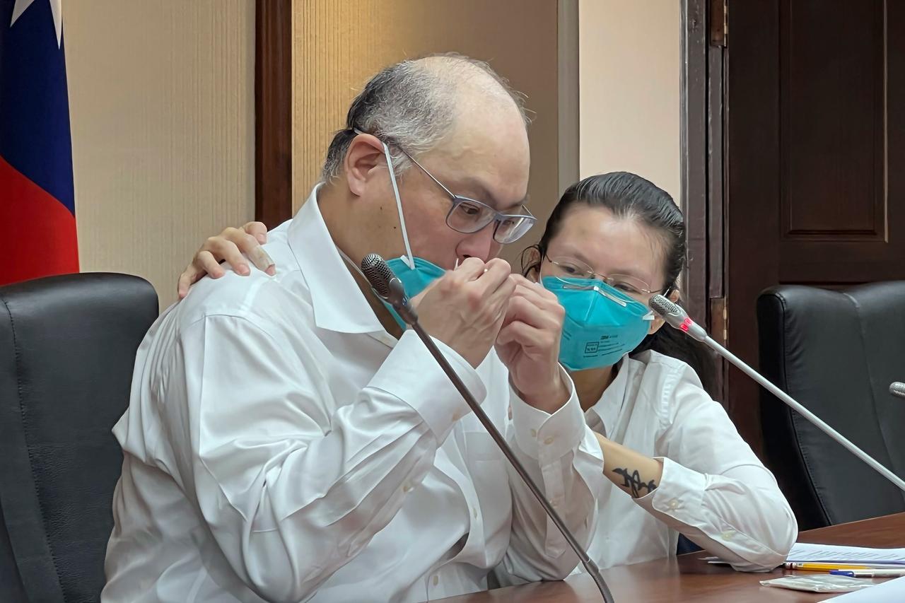 Ein weiß gekleideter Mann und eine weiß gekleidete Frau sitzen an einem Pult mit Mikrofonen: der taiwanesische Menschenrechtsaktivist Lee Ming-che und seine Frau Lee Ching-yu.