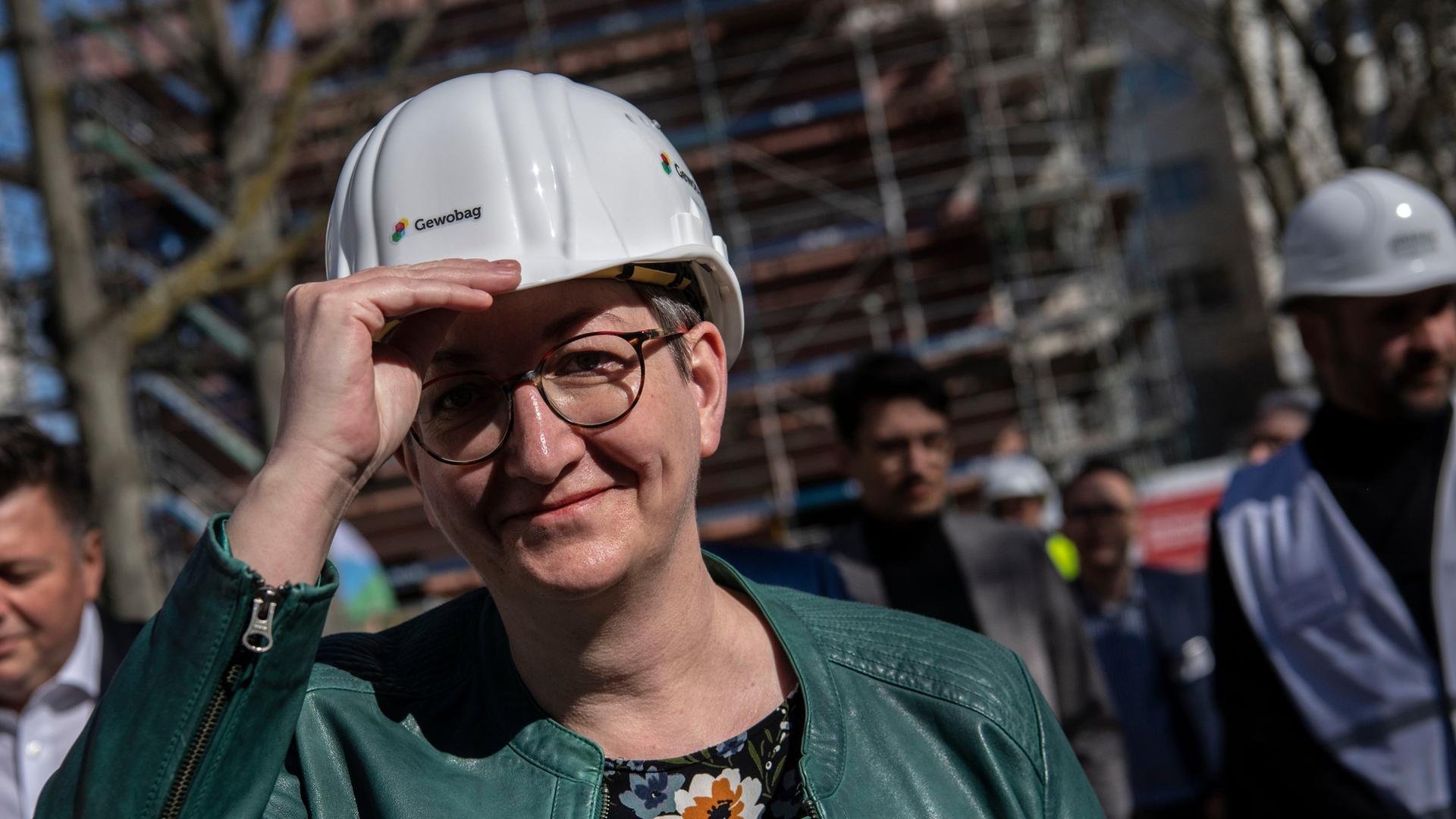 Bundesbauministerin Klara Geywitz (SPD) trägt bei einem Baustellenrundgang einen Helm.