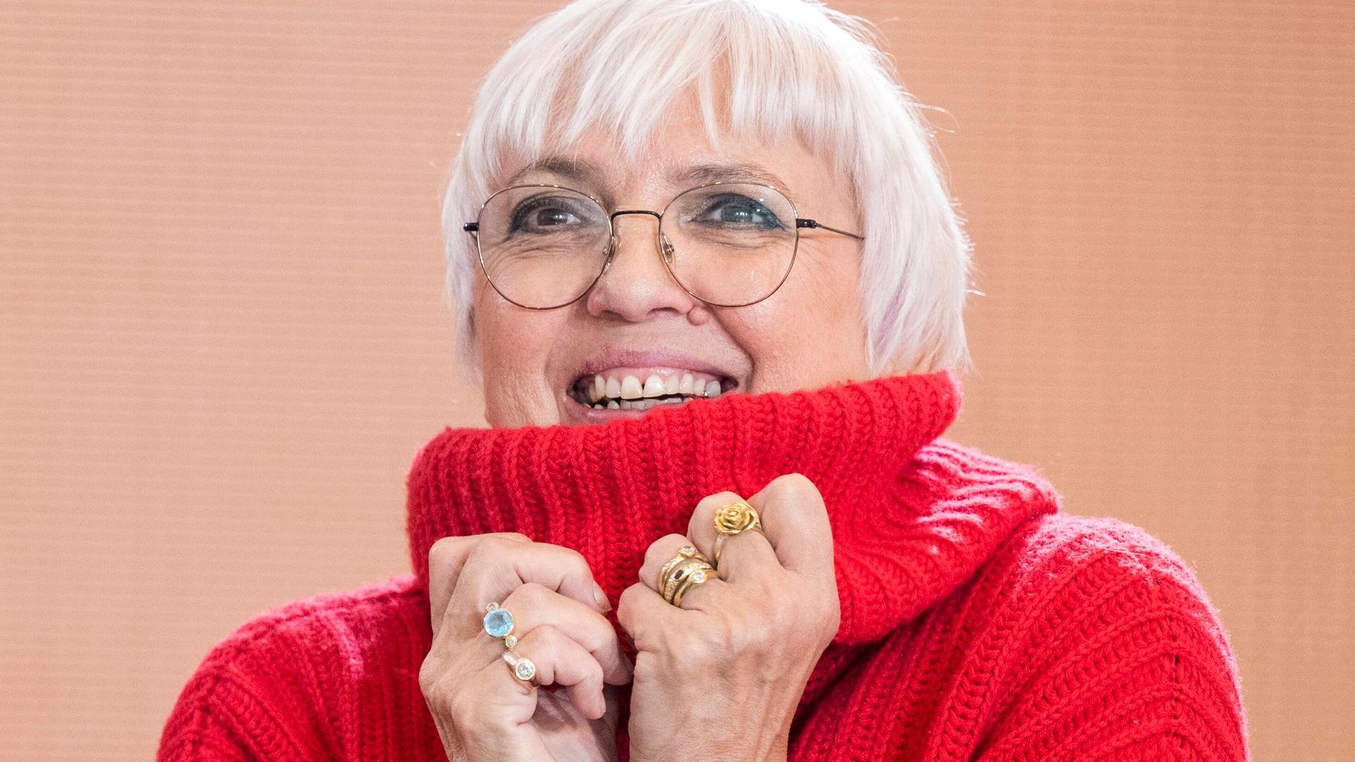 Porträt der Kulturstaatsministerin Claudia Roth, sie trägt einen roten Rollkragenpullover und lacht. Porträt der Kulturstaatsministerin Claudia Roth, sie trägt einen roten Rollkragenpullover und lacht.