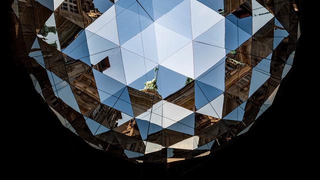Blick in ein Kaleidoskop, Elemente der umliegenden Häuser und des Rathauses in Hamburg sind zu sehen. 