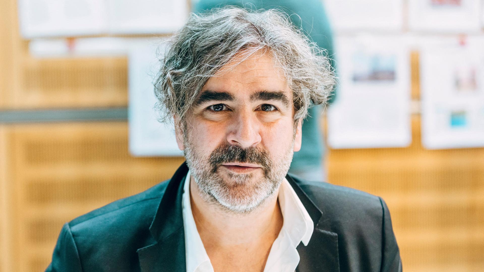 Der Journalist Deniz Yücel blickt in die Kamera. Er trägt ein dunkles Sakko und einen kurzen, graumelierten Bart. Der Journalist Deniz Yücel blickt in die Kamera. Er trägt ein dunkles Sakko und einen kurzen, graumelierten Bart.