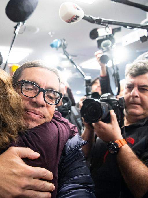 Jens Söring wird nach seiner Ankunft am Flughafen von einer Unterstützerin umarmt. Nach mehr als drei Jahrzehnten in Haft trifft der Diplomatensohn Jens Söring 2019 am Flughafen ein. 