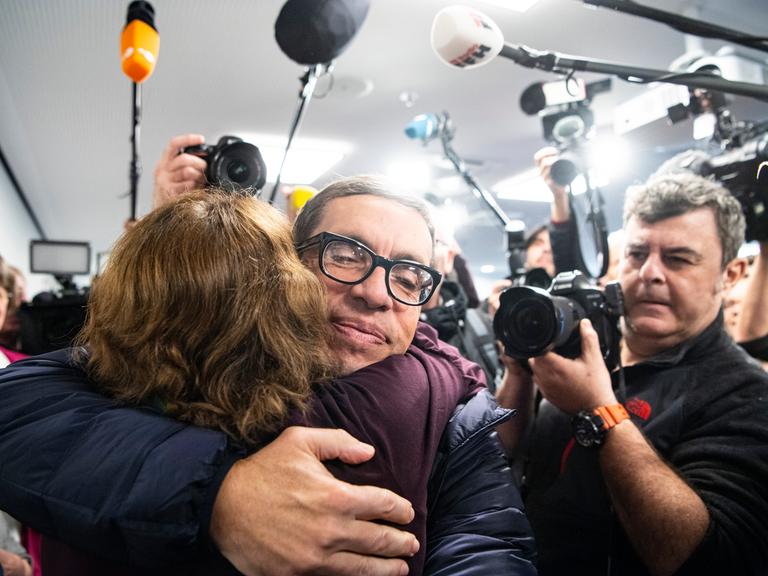 Jens Söring wird nach seiner Ankunft am Flughafen von einer Unterstützerin umarmt. Nach mehr als drei Jahrzehnten in Haft trifft der Diplomatensohn Jens Söring 2019 am Flughafen ein. 