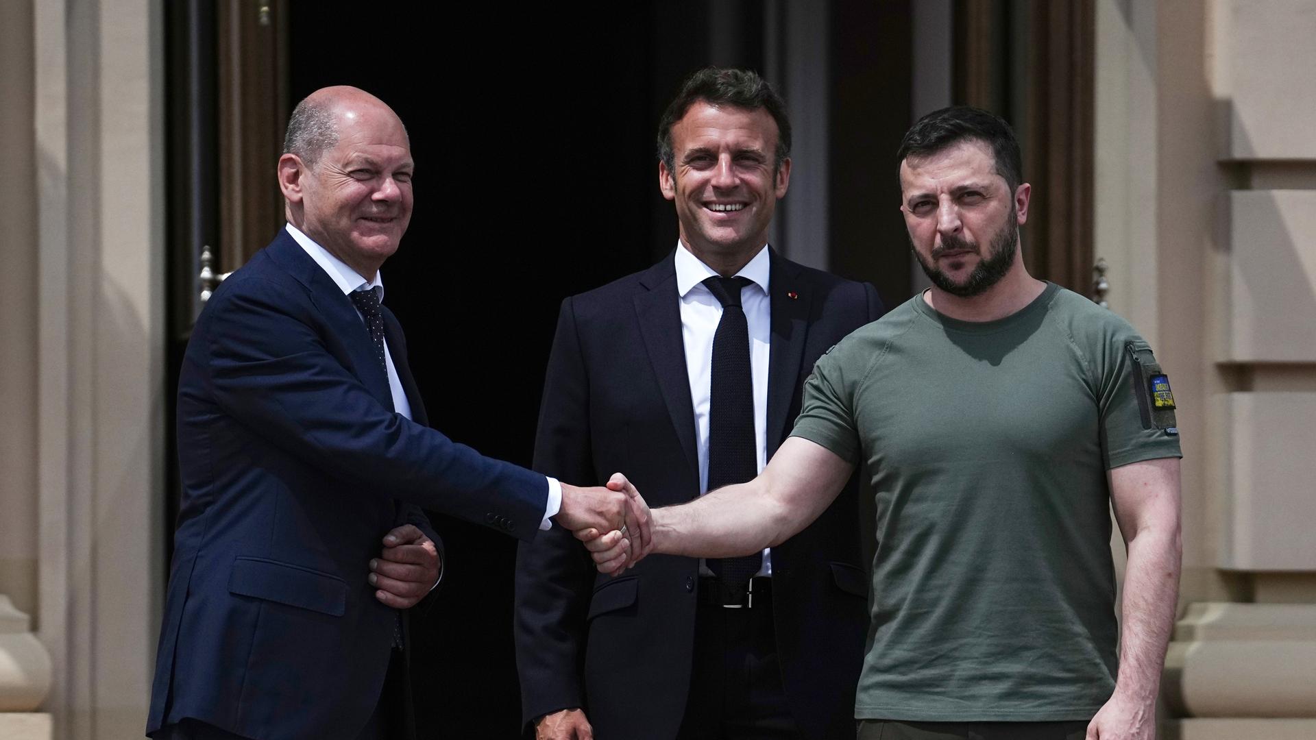 Wolodymyr Selenskyj (r), Präsident der Ukraine, begrüßt Bundeskanzler Olaf Scholz (l, SPD) und Emmanuel Macron (M), Präsident von Frankreich Wolodymyr Selenskyj (r), Präsident der Ukraine, begrüßt Bundeskanzler Olaf Scholz (l, SPD) und Emmanuel Macron (M), Präsident von Frankreich