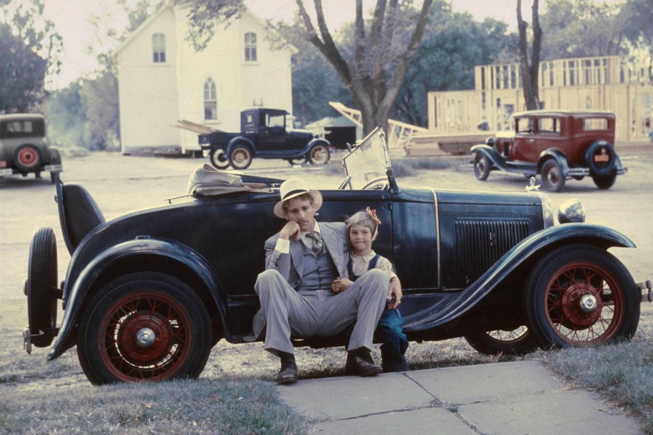 Die Schauspieler Ryan und Tatum O'Neal sitzen vor einem Auto der 30er-Jahre Die Schauspieler Ryan und Tatum O'Neal sitzen vor einem Auto der 30er-Jahre