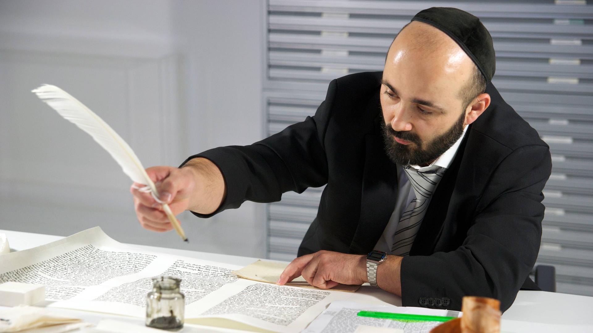 Der Rabbiner Reuven Yaacobov schreibt mit Feder und Tinte im Jüdischen Museum Berlin eine Torarolle. Der Rabbiner Reuven Yaacobov schreibt mit Feder und Tinte im Jüdischen Museum Berlin eine Torarolle.