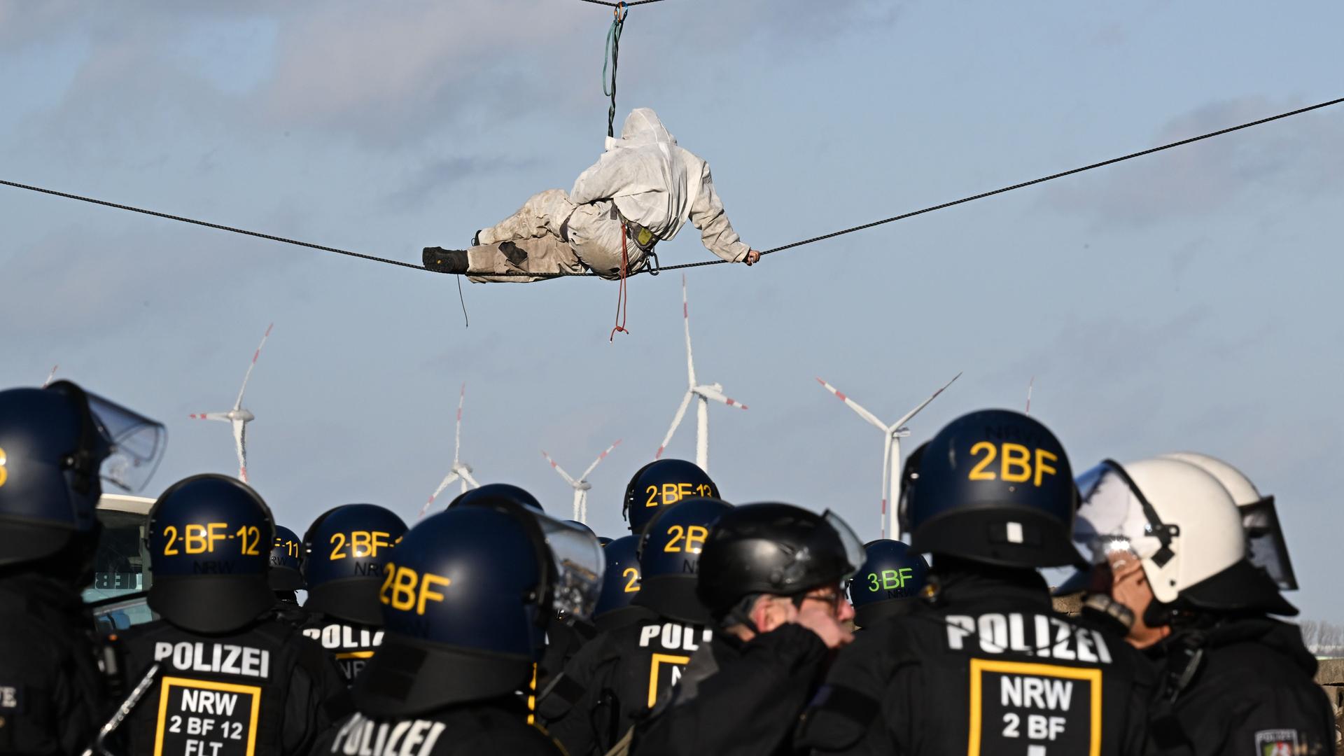 Ein Demonstrant sitzt während der Räumung des Dorfes Lützerath auf einem Drahtseil. Der Energiekonzern RWE will die unter Lützerath liegende Kohle abbaggern - dafür soll der Weiler auf dem Gebiet der Stadt Erkelenz am Braunkohletagebau Garzweiler II abgerissen werden. Ein Demonstrant sitzt während der Räumung des Dorfes Lützerath auf einem Drahtseil. Der Energiekonzern RWE will die unter Lützerath liegende Kohle abbaggern - dafür soll der Weiler auf dem Gebiet der Stadt Erkelenz am Braunkohletagebau Garzweiler II abgerissen werden.