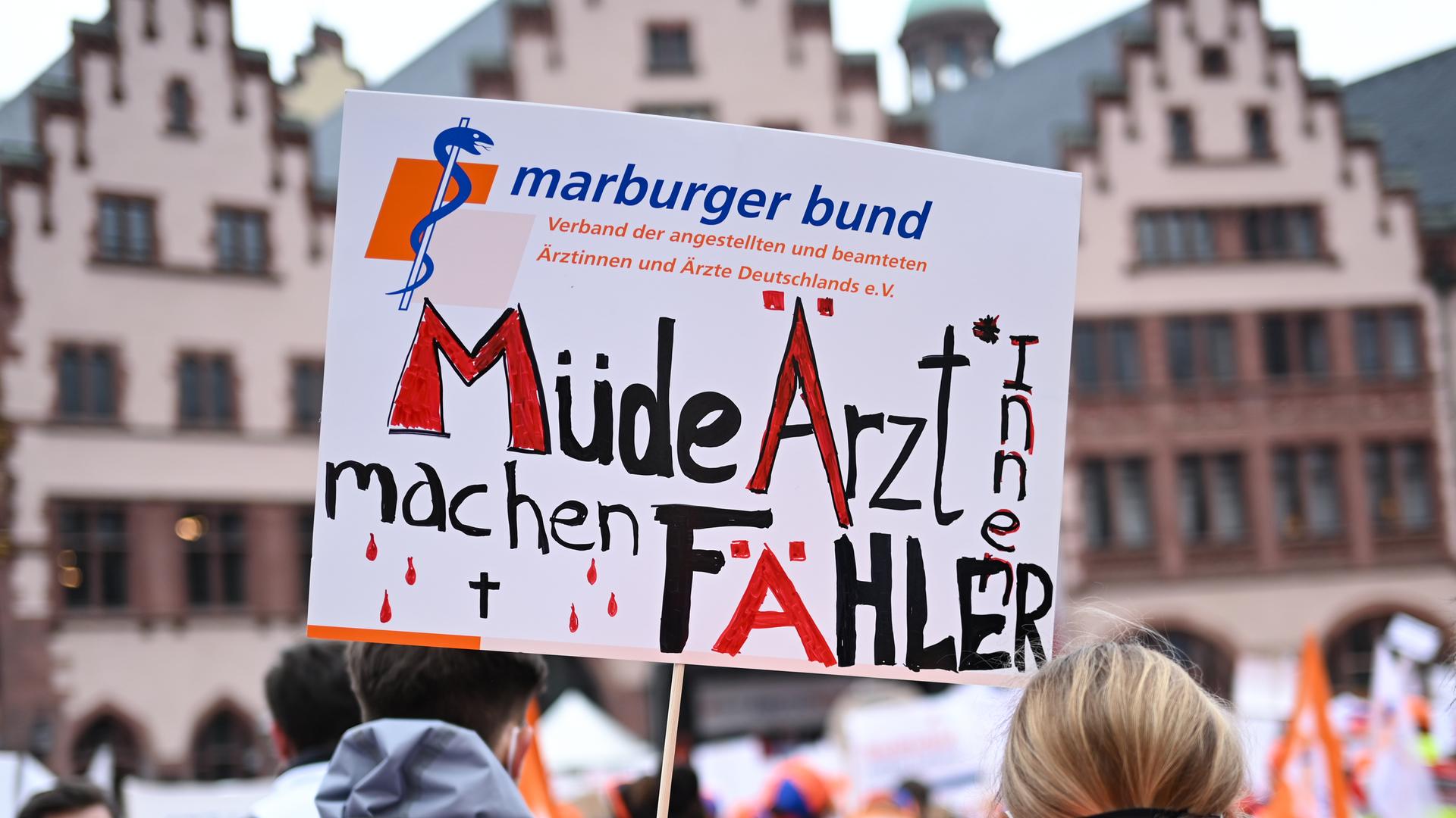 Eine Frau hält bei einer Kundgebung des Marburger Bund auf dem Römerberg ein Plakat mit der Aufschrift "Müde Ärzt*innen machen Fähler". Das Wort Fehler ist absichtlich falsch mit "ä" geschrieben. Eine Frau hält bei einer Kundgebung des Marburger Bund auf dem Römerberg ein Plakat mit der Aufschrift "Müde Ärzt*innen machen Fähler". Das Wort Fehler ist absichtlich falsch mit "ä" geschrieben.