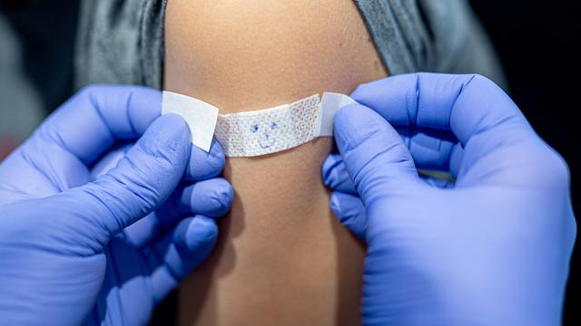 Pflaster mit aufgemaltem Gesicht auf den Arm Pflaster mit aufgemaltem Gesicht auf den Arm