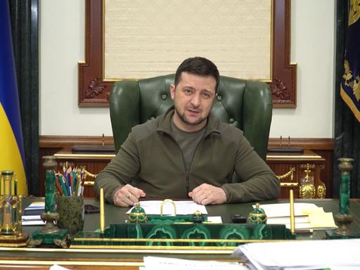 Der ukrainische Präsident Selenskyi sitzt an einem Schreibtisch.