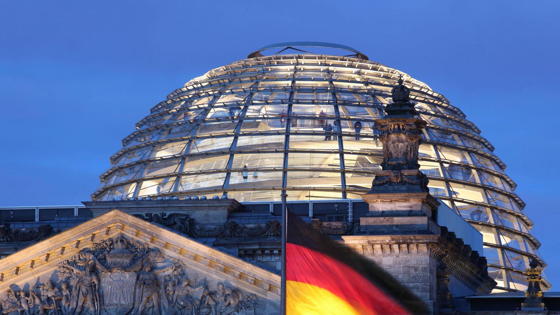 Vor der Reichstagskuppel und dem Reichstag weht eine schwarz-rot-goldene Deutschland-Fahne Vor der Reichstagskuppel und dem Reichstag weht eine schwarz-rot-goldene Deutschland-Fahne