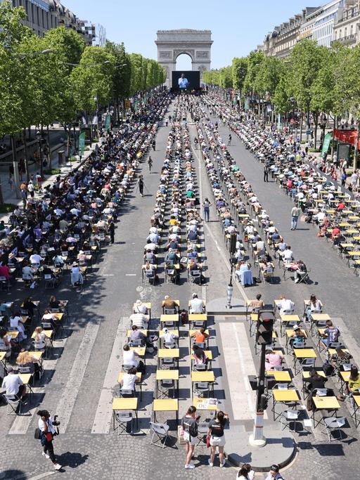 Schreibpulte für bis zu 1.700 Teilnehmende auf der Prachtstraße bis hin zum Triumphbogen in Paris.