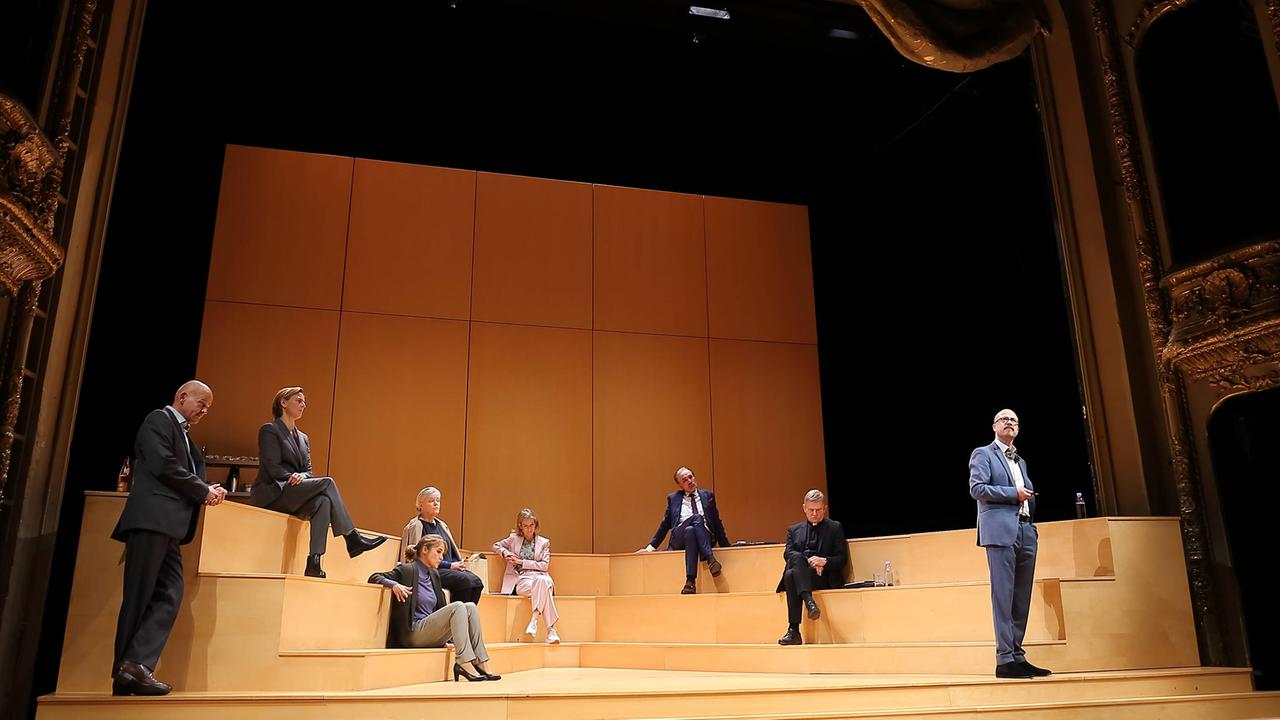 Acht SchauspielerInnen stehen oder sitzen auf einem Holzpodest, Fotoprobe im Berliner Ensemble, 8. September 2020 für das Theaterstück "Gott" von Ferdinand von Schirach. Von links nach rechts: Martin Rentzsch als Biegler, Rechtsanwalt, Bettina Hoppe als Keller, Mitglied des Ethikrates, Josefin Platt als Elisabeth Gärtner, Christine Schönfeld als Brandt, Augenärztin, Judith Engel als Litten, Rechtssachverständige, Ingo Hülsmann als Sperling, medizinischer Sachverständiger, Veit Schubert als Thiel, theologischer Sachverständiger und Gerrit Jansen als Vorsitzender des Ethikrates Acht SchauspielerInnen stehen oder sitzen auf einem Holzpodest, Fotoprobe im Berliner Ensemble, 8. September 2020 für das Theaterstück "Gott" von Ferdinand von Schirach. Von links nach rechts: Martin Rentzsch als Biegler, Rechtsanwalt, Bettina Hoppe als Keller, Mitglied des Ethikrates, Josefin Platt als Elisabeth Gärtner, Christine Schönfeld als Brandt, Augenärztin, Judith Engel als Litten, Rechtssachverständige, Ingo Hülsmann als Sperling, medizinischer Sachverständiger, Veit Schubert als Thiel, theologischer Sachverständiger und Gerrit Jansen als Vorsitzender des Ethikrates