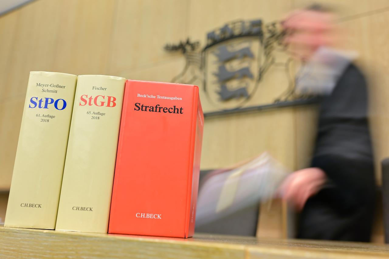 Ein Richter geht in einem Sitzungssaal des Landgerichts an der Richterbank zu seinem Sitzplatz. Im Vordergrund stehen Gesetzestexte. Ein Richter geht in einem Sitzungssaal des Landgerichts an der Richterbank zu seinem Sitzplatz. Im Vordergrund stehen Gesetzestexte.