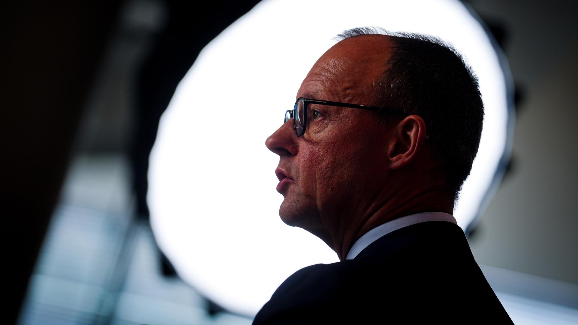 Der CDU-Parteivorsitzende Friedrich Merz ist im Profil vor einem kreisrunden hellen Hintergrund zu sehen. Der CDU-Parteivorsitzende Friedrich Merz ist im Profil vor einem kreisrunden hellen Hintergrund zu sehen.