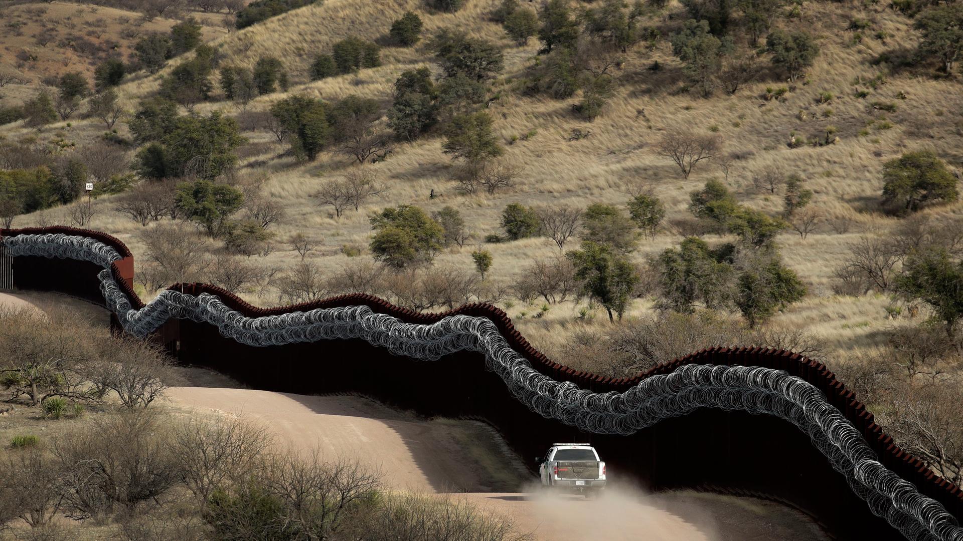 Eine Fahrzeug der Grenzsicherung fährt entlang der Mauer in Arizona Eine Fahrzeug der Grenzsicherung fährt entlang der Mauer in Arizona