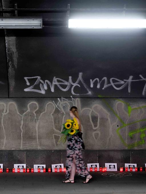 Kerzen und Karten mit den Namen der 21 Opfer stehen am 10. Jahrestag der Loveparade-Katastrophe in einem Tunnel, der zum Ort der Katastrophe führt. Bei der Loveparade am 24. Juli 2010 starben am einzigen Zu- und Abgang zum Veranstaltungsgelände in einem Gedränge 21 junge Menschen.
