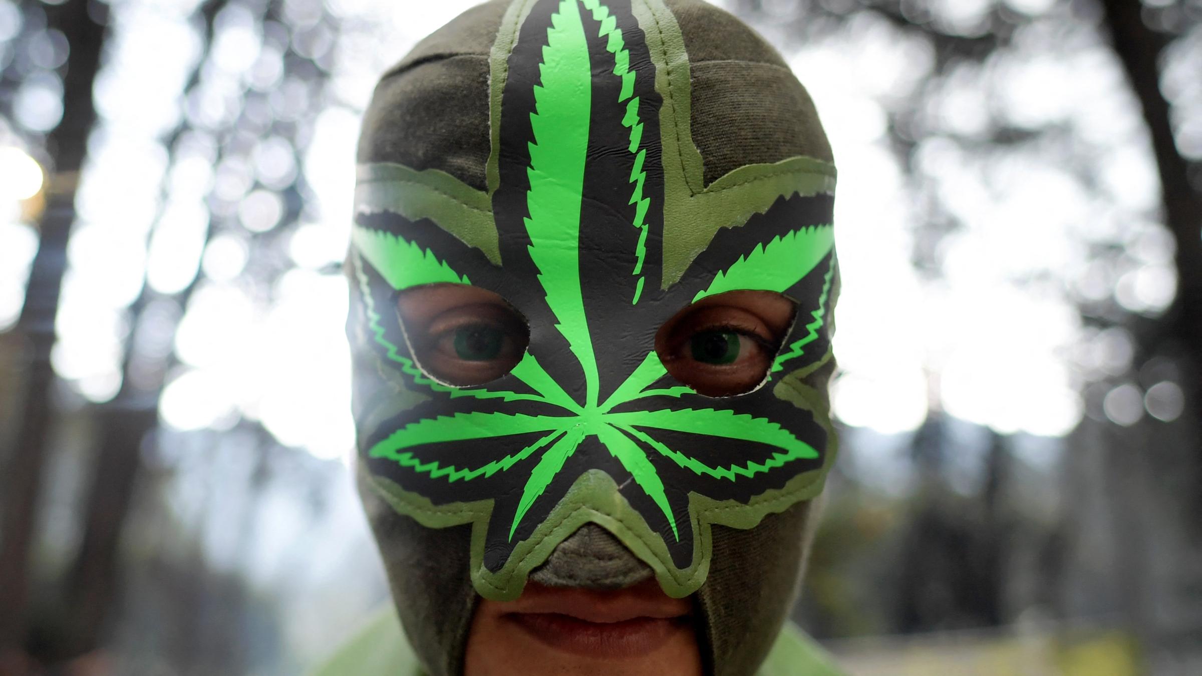 Ein Mann trägt eine Maske mit der Darstellung eines Cannabisblattes.