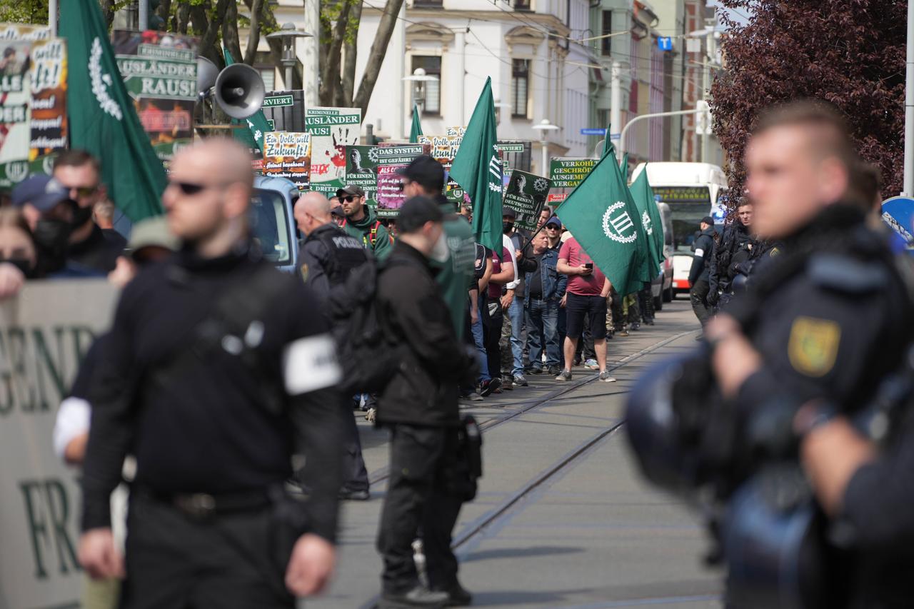 Auf dem von der rechtsextremen Splitterpartei "Der III. Weg" organisierten Aufzug am 1. Mai 2022 sind Demonstranten mit Fahnen zu sehen, im Vordergrund stehen schwarz gekleidete Personen. 