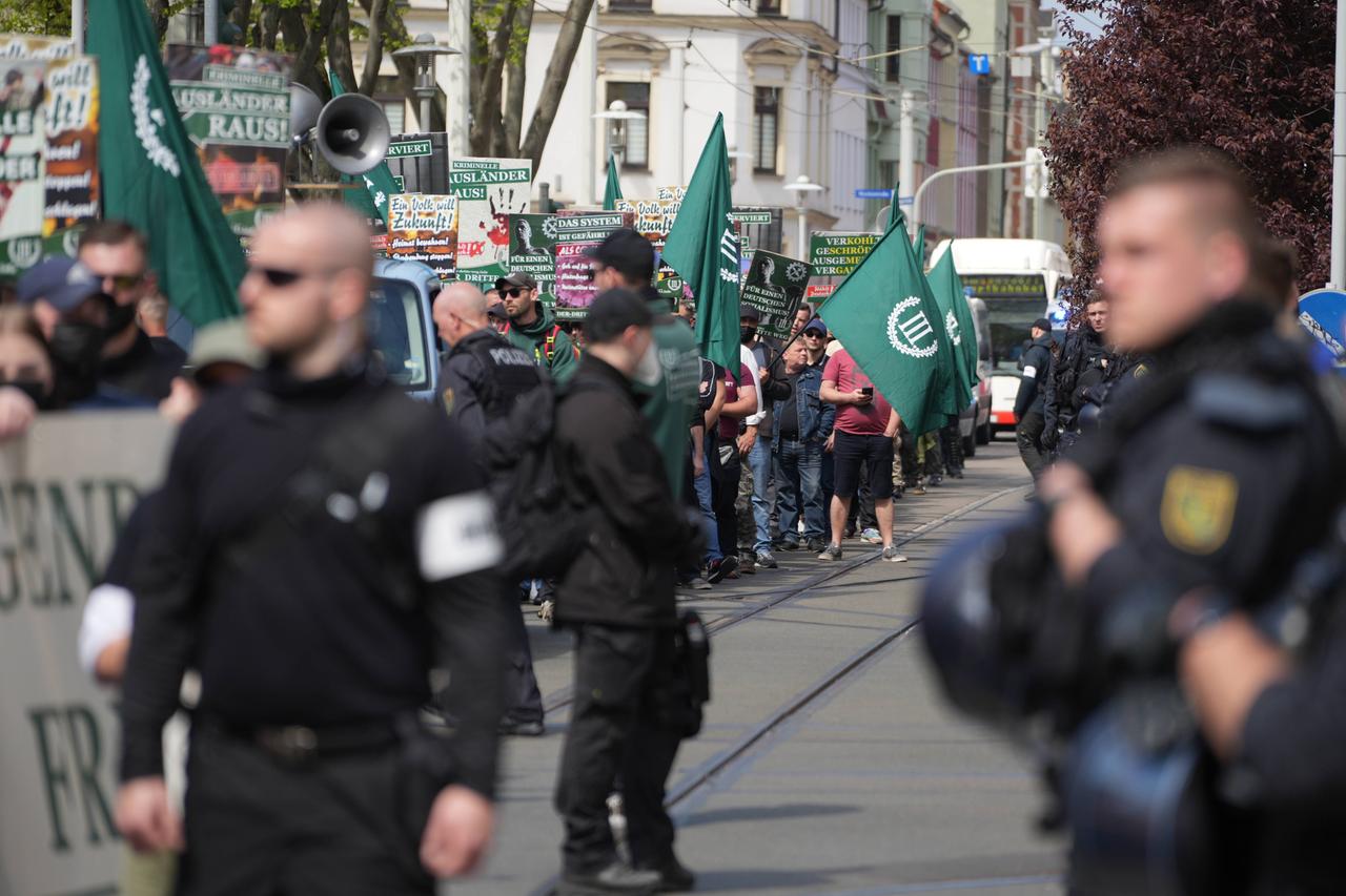Auf dem von der rechtsextremen Splitterpartei "Der III. Weg" organisierten Aufzug am 1. Mai 2022 sind Demonstranten mit Fahnen zu sehen, im Vordergrund stehen schwarz gekleidete Personen. Auf dem von der rechtsextremen Splitterpartei "Der III. Weg" organisierten Aufzug am 1. Mai 2022 sind Demonstranten mit Fahnen zu sehen, im Vordergrund stehen schwarz gekleidete Personen.