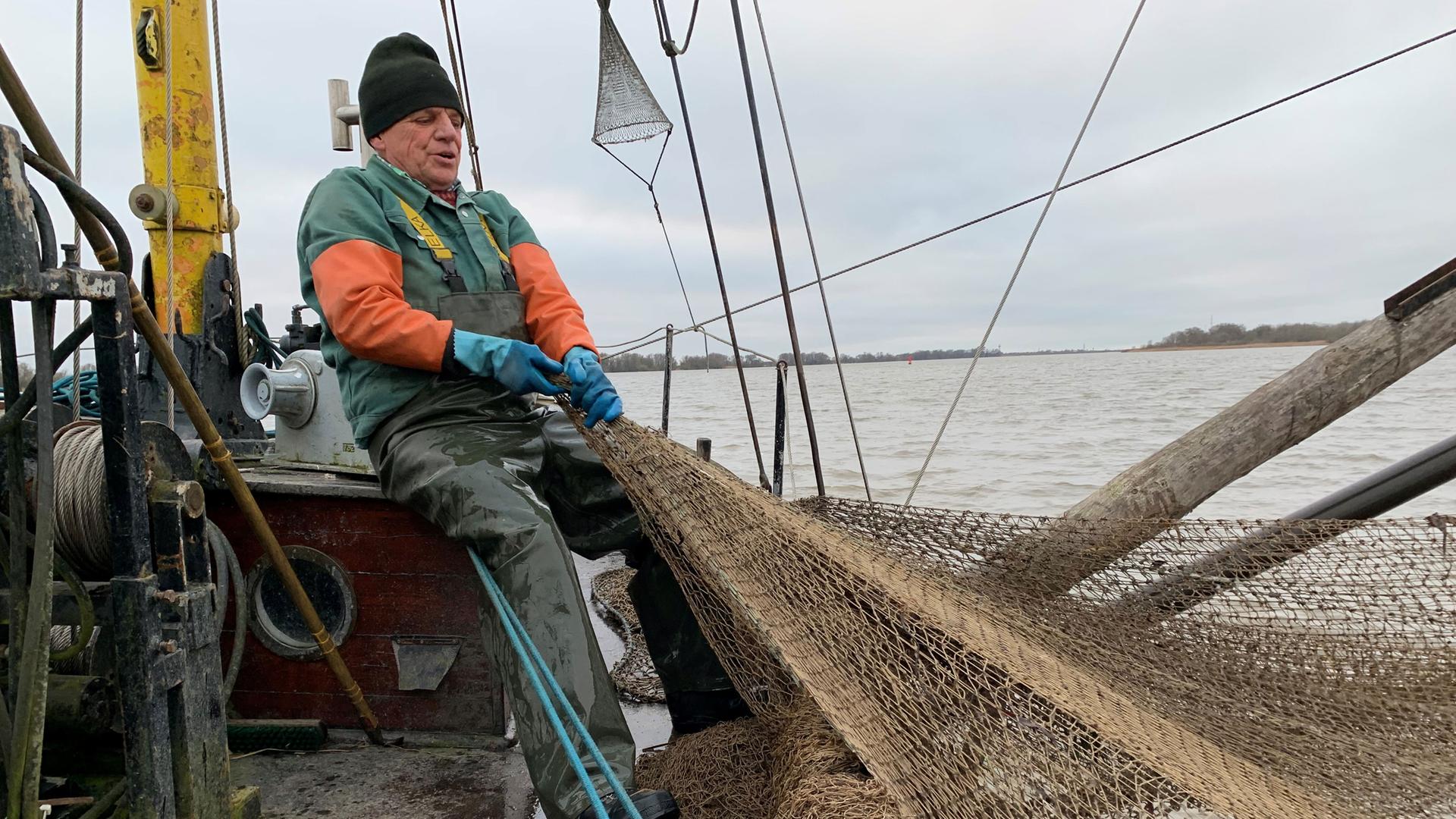 Fischer Lothar holt bei eisigen Temperaturen auf der Elbe seine Netze ein Fischer Lothar holt bei eisigen Temperaturen auf der Elbe seine Netze ein