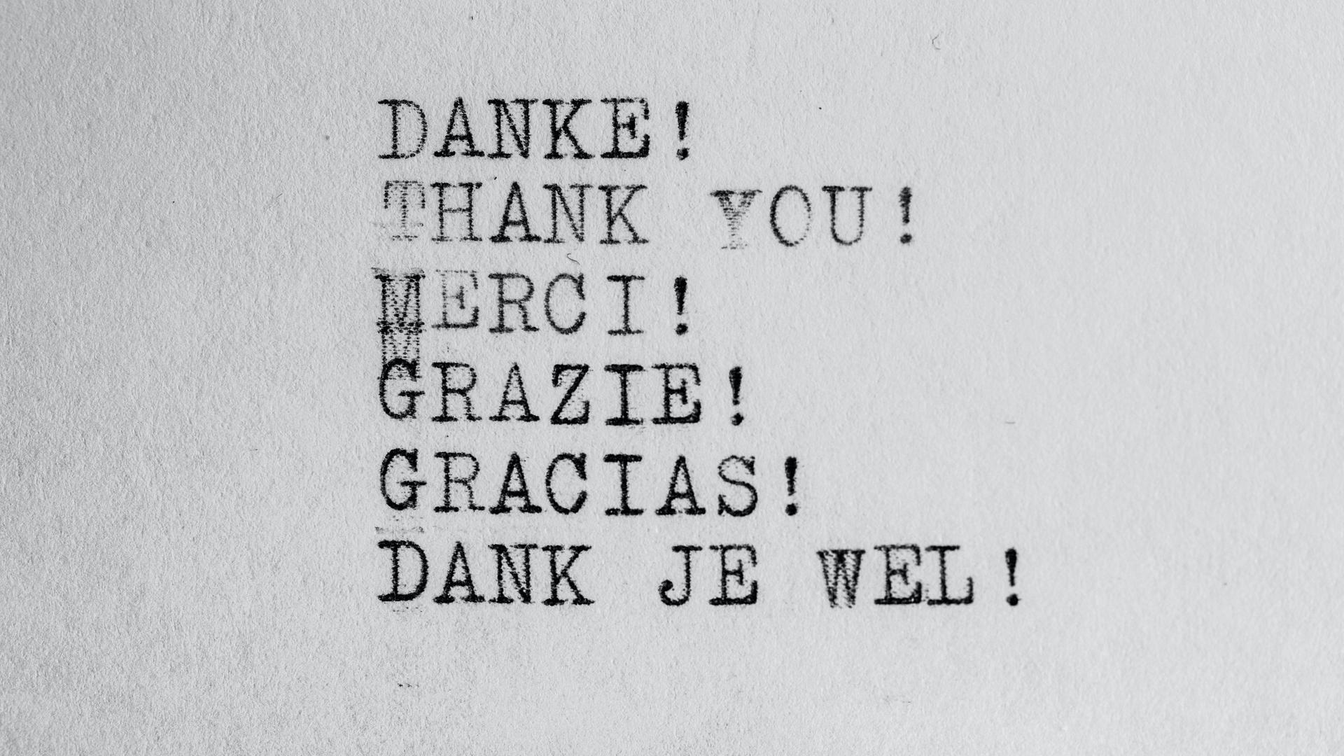 Wir sehen ein Blatt Papier auf dem das Wort "Danke" in verschiendenen Sprachen mit einer Schreibmaschine geschrieben steht. Wir sehen ein Blatt Papier auf dem das Wort "Danke" in verschiendenen Sprachen mit einer Schreibmaschine geschrieben steht.