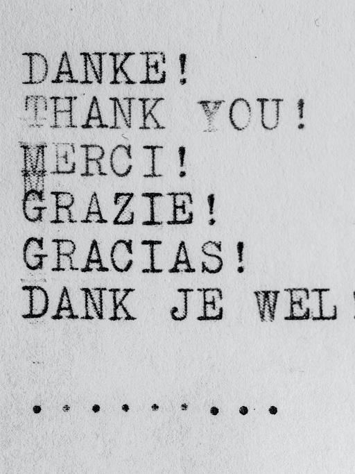 Wir sehen ein Blatt Papier auf dem das Wort "Danke" in verschiendenen Sprachen mit einer Schreibmaschine geschrieben steht. 