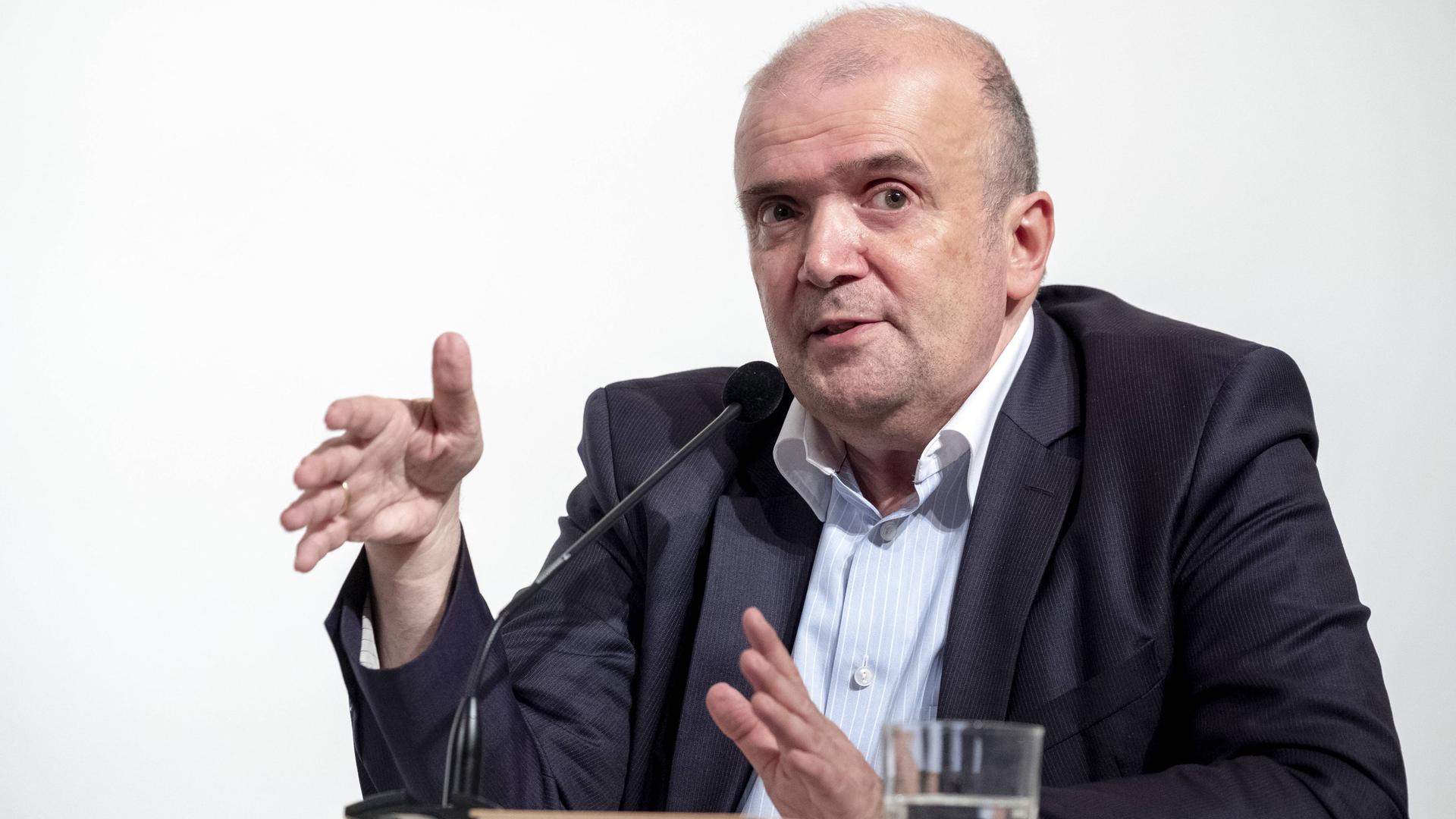 Der Lyrikkritiker Michael Braun gestikuliert an einem Tisch vor einem Mikrofon. Der Lyrikkritiker Michael Braun gestikuliert an einem Tisch vor einem Mikrofon.