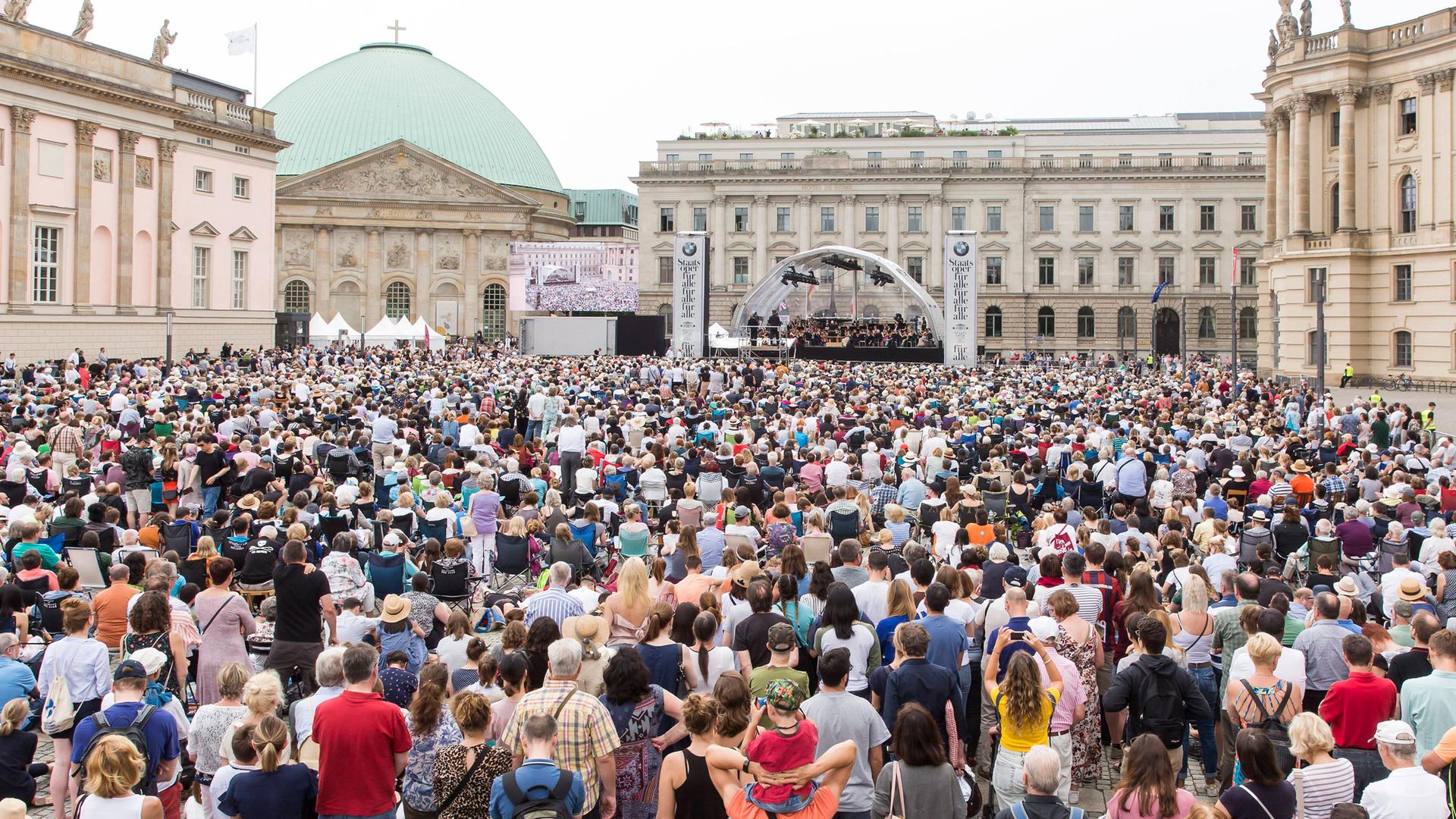 Blick auf den Bebelplatz in Berlin, wo viele Menschen einem Konzert zuhören Blick auf den Bebelplatz in Berlin, wo viele Menschen einem Konzert zuhören