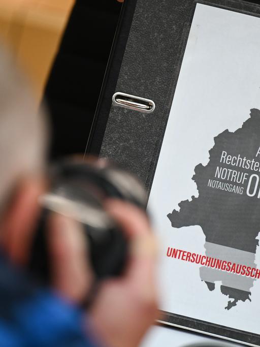 Ein Aktenordner mit der Aufschrift "Aufklärung Rechtsterrorismus Notruf Notausgang Opfer Hanau Untersuchungsausschuss 20/2" liegt beim Auftakt des Untersuchungsausschusses zum rassistischen Anschlag von Hanau 2020 auf dem Platz einer SPD-Abgeordneten.