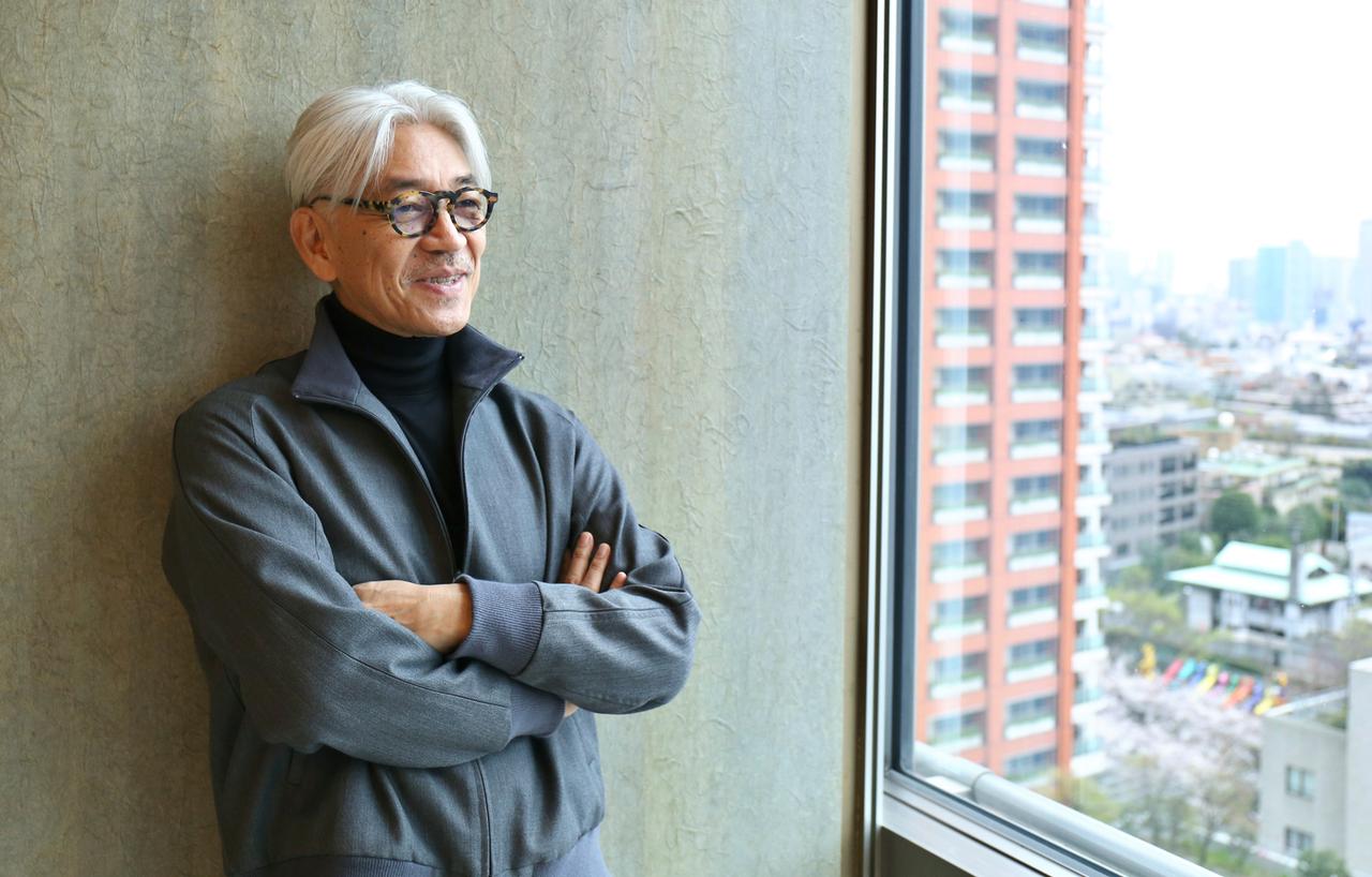 Der japanische Komponist und Pianist Ryūichi Sakamoto lehnt an einer Wand. Der japanische Komponist und Pianist Ryūichi Sakamoto lehnt an einer Wand.