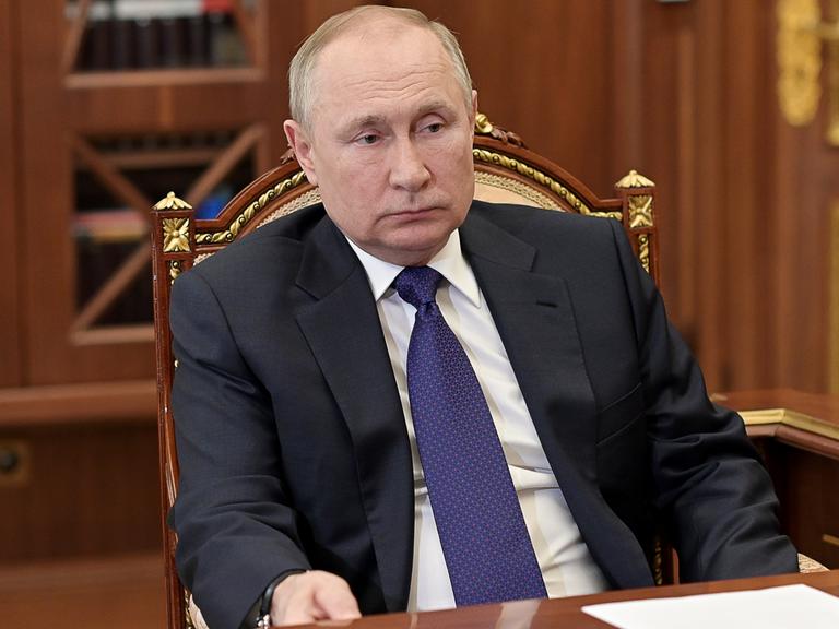 Der russische Präsident Putin sitzt an einem Schreibtisch.