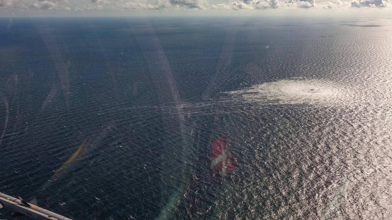 Blick aus einem Hubschrauber auf eine Wasserfläche mit einem großen Kreis von Wasserblasen.