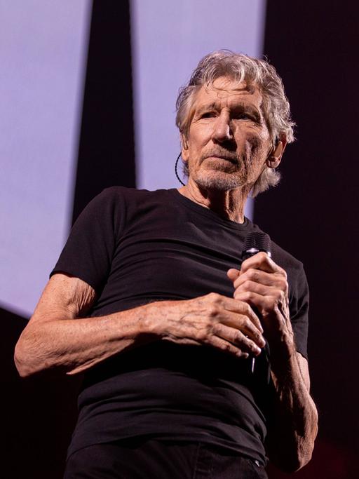 Roger Waters steht auf einer Bühne.