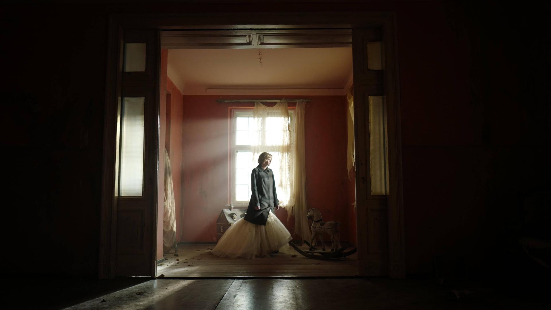 Filmstill aus "Spencer": Kristen Stewart als Prinzessin Diana steht allein in einem Zimmer. 