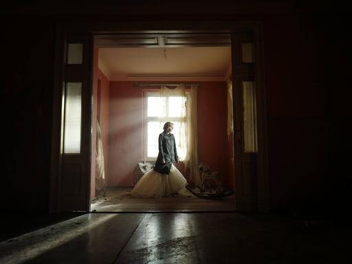 Filmstill aus "Spencer": Kristen Stewart als Prinzessin Diana steht allein in einem Zimmer. 