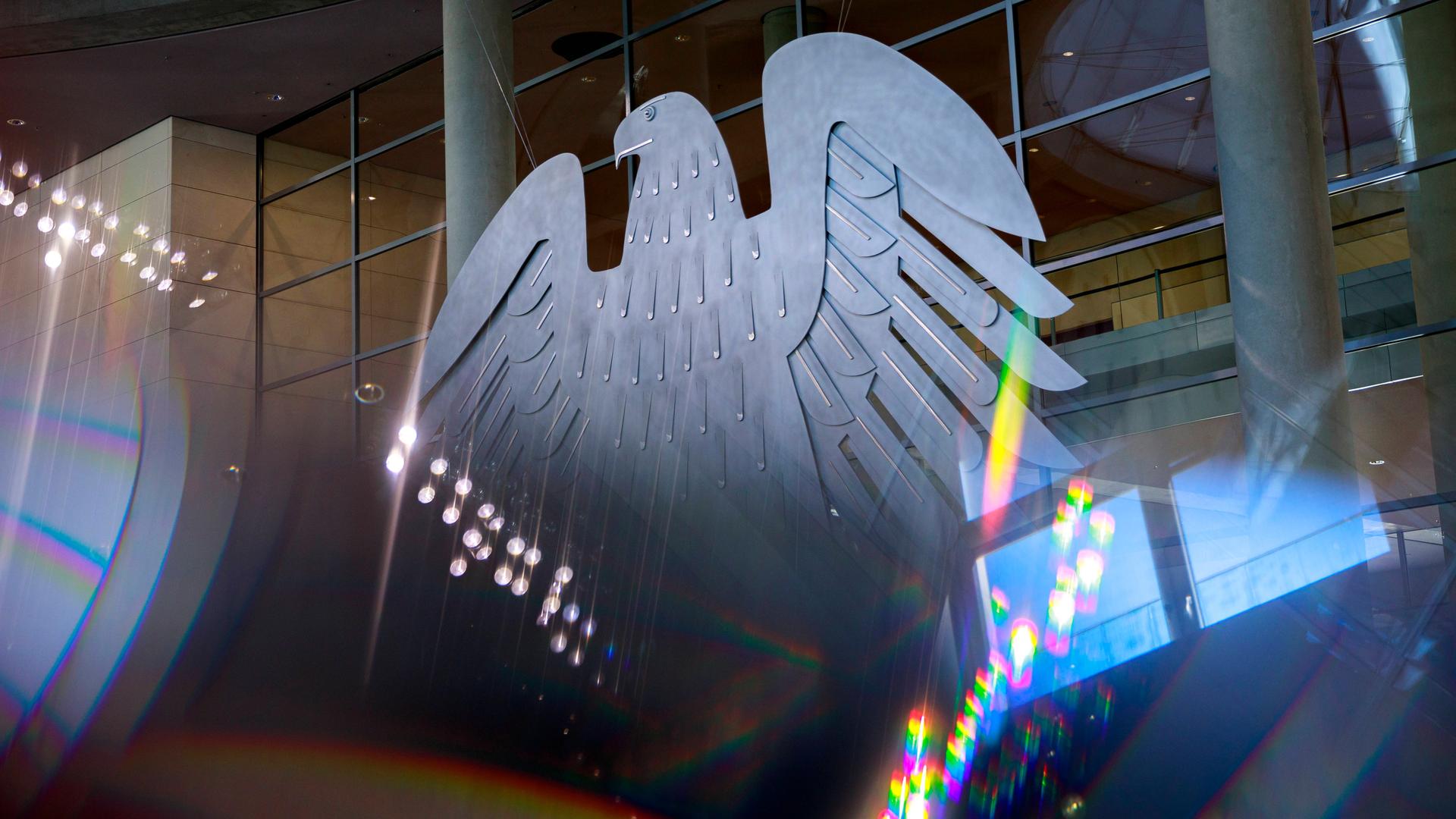 Der Bundesadler mit Lichtreflektionen im Plenarsaal des Deutschen Bundestages