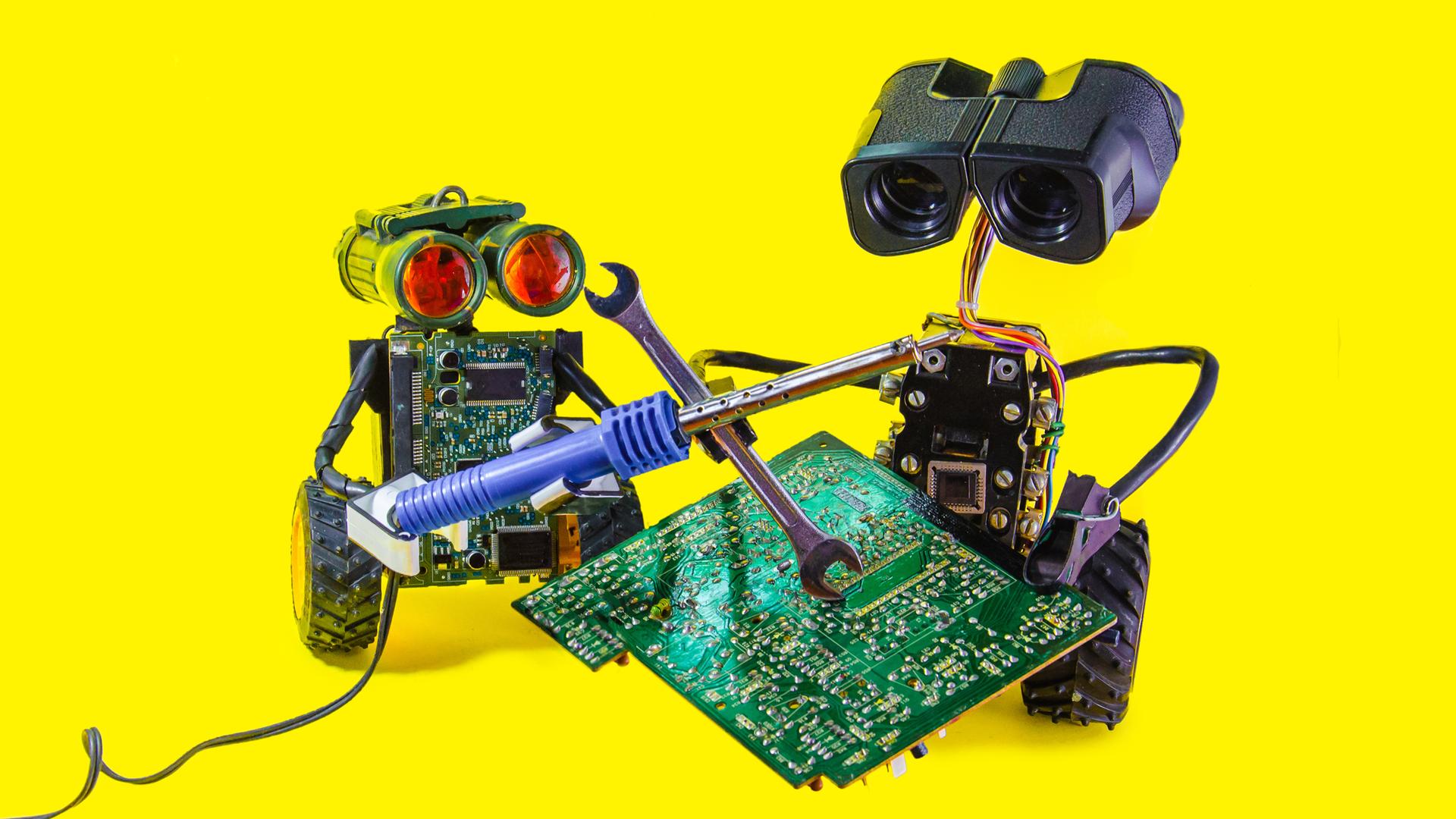 Zwei fröhliche spielzeugartige Roboter reparieren eine Leiterplatte mit Lötkolben vor knallgelbem Hintergrund. 