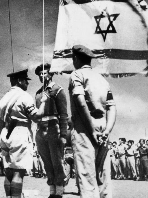Historische Schwarz-weiß-Aufnahme zeigt das zeremonielle Aufziehen der israelische Flagge am 14. Mai 1948 zur Gründung des Staates Israel.