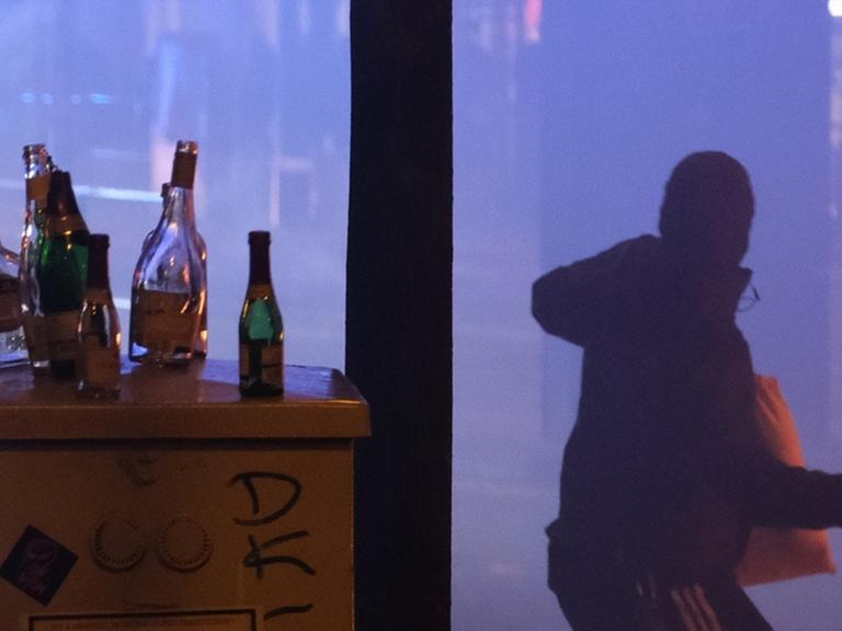Ein Mann wirft mit einer Flasche in Richtung von Polizisten. In der Nacht zu Neujahr ist es im Stadtteil Connewitz zu Zusammenstößen zwischen Randalierern und der Polizei gekommen.
