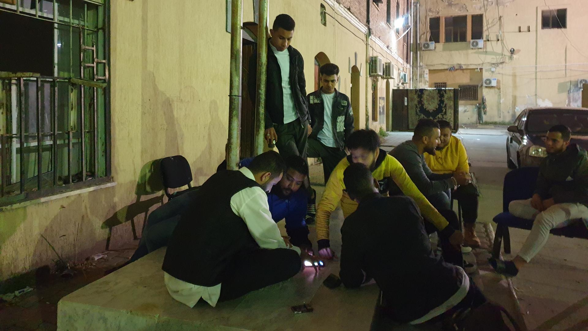 Asaad Jafar und seine Freunde vom libyschen Roten Halbmond beim Ludo-Spielen in Tripolis in einem Hinterhof bei Nacht Asaad Jafar und seine Freunde vom libyschen Roten Halbmond beim Ludo-Spielen in Tripolis in einem Hinterhof bei Nacht