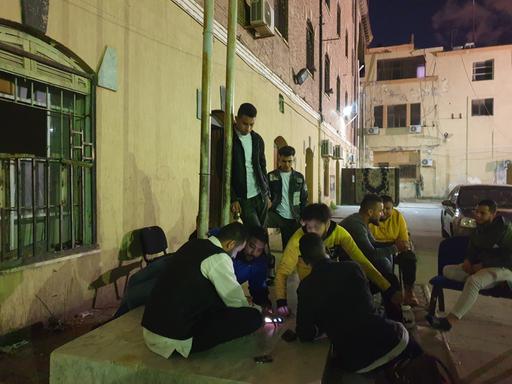 Asaad Jafar und seine Freunde vom libyschen Roten Halbmond beim Ludo-Spielen in Tripolis in einem Hinterhof bei Nacht
