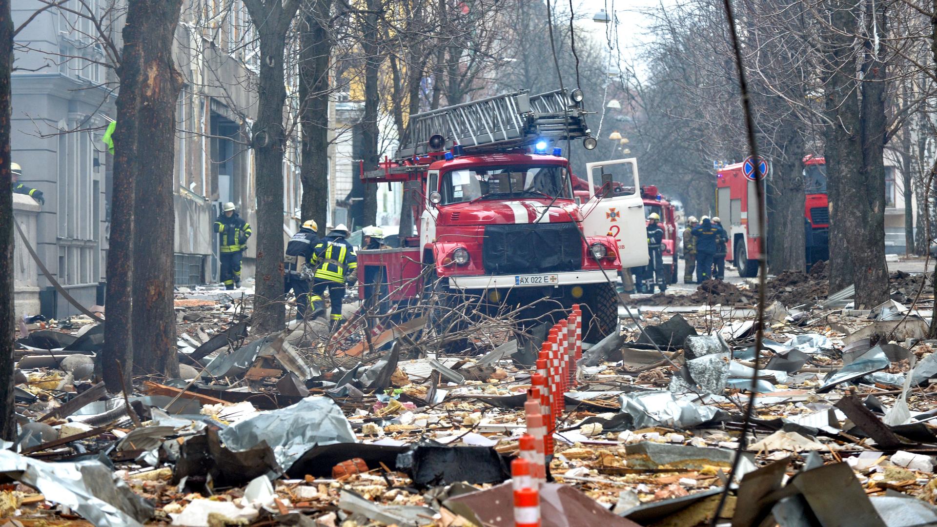 Feuerwehrmänner räumen Schutt und Asche vom Angriff in der ukrainischen Stadt Charkiw weg.